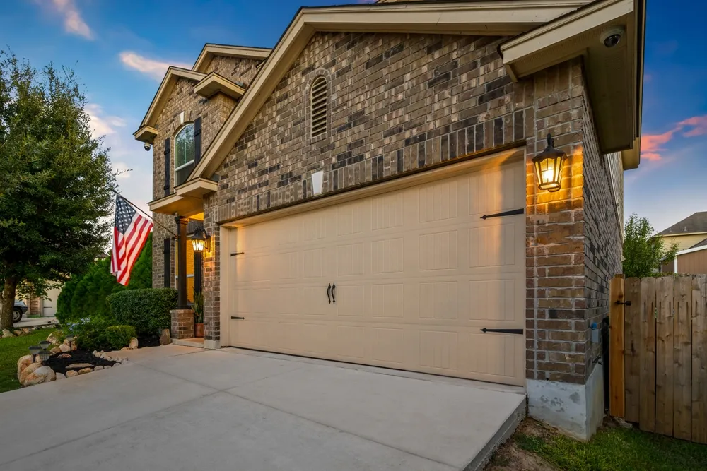 Brick home with carriage style garage door at twilight