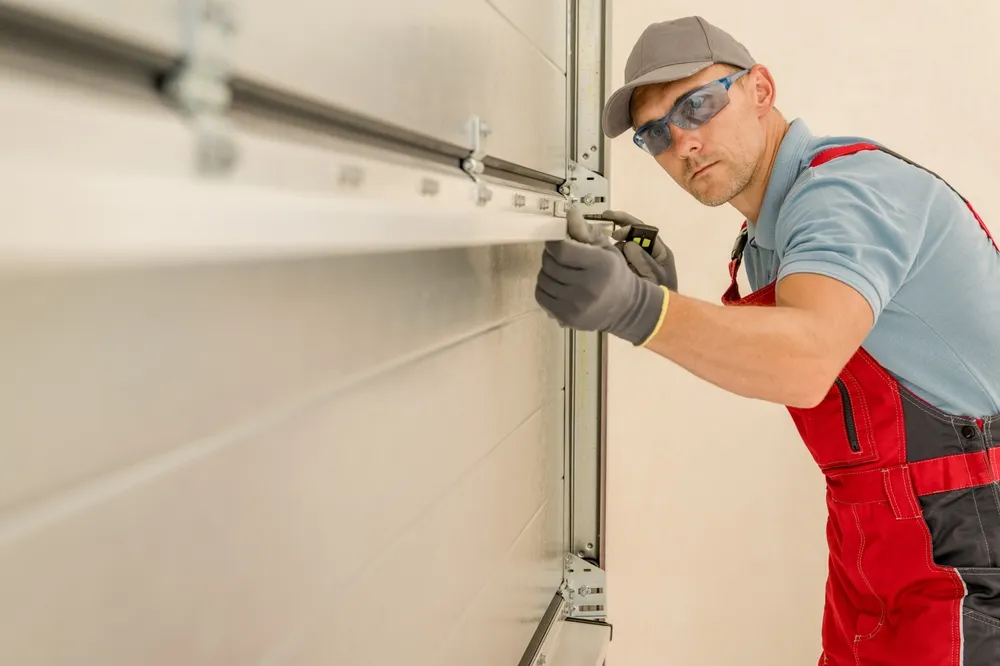 Garage door technician adjusting door components